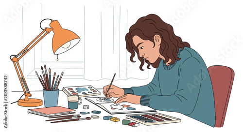 Young female artist painting in sketchbook at desk with art supplies