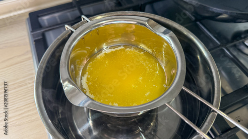 Melted butter in a double boiler on a gas stove warm light ideal for recipe blog food photography cooking tutorial and social posts, 5 May 2026 Subitica, Serbia