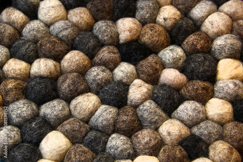 Natural felt wool ball texture with neutral earth tone, handcrafted textile pattern