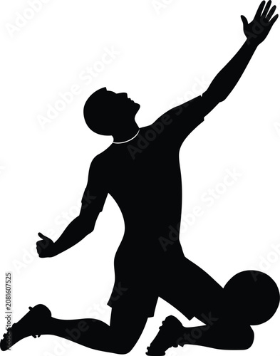 Silhouette of a male soccer player kneeling on the ground and celebrating a goal in a match