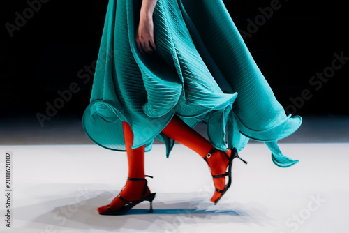 Foto Ruffled green dress on a female figure and bright red tights, fancy woman's outf
