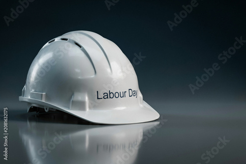 Striking three dimensional metallic silver text spelling Labour Day against a dynamic backdrop of abstract flowing industrial steel metal waves with visible rivets and intricate patterns