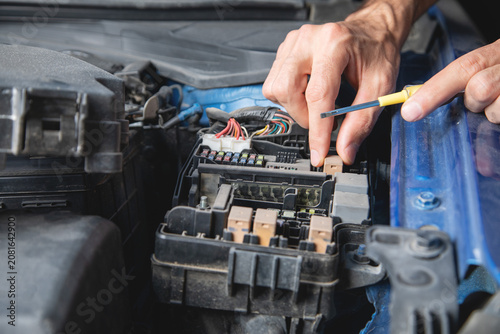 Technician checking car fuse. Car maintenance