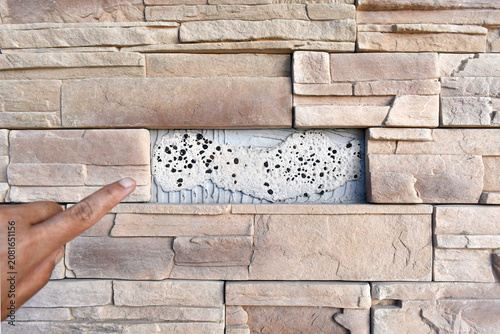 Fotografie Faux stone fell off the wall texture background.