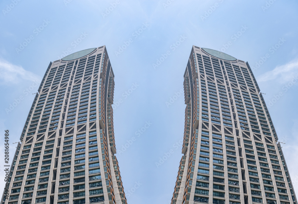 Fototapeta premium a digitally composed fine art architectural photograph created by mirroring and joining sections of a modern glass skyscraper