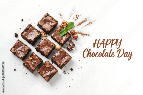 Delicious homemade chocolate brownies squares arranged in a grid pattern with green mint leaves for happy chocolate day celebration with sweet cocoa dessert treats for a tasty snack