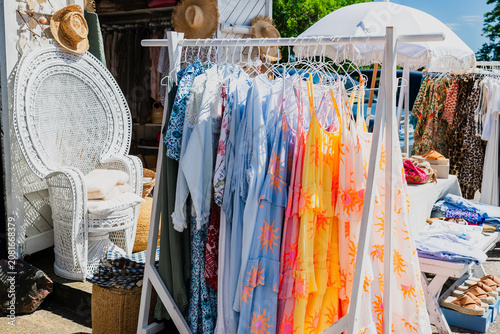 Stylish summer clothing collection on outdoor market rack with pastel linen fashion and casual apparel