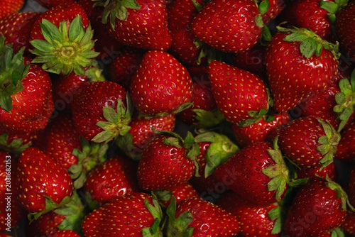 Fresh ripe strawberries close up with green leaves