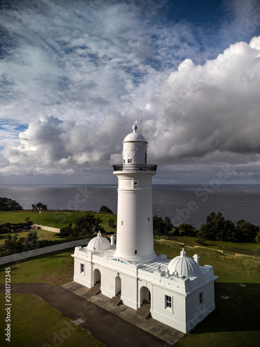 MacQuarie lighthouse vertical in Sydney, Australia from aerial view with ocean and dramatic stormy sky in the background
