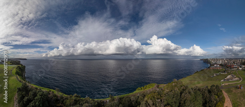 Panorama of Christison Park, Sydney with view of cliffs and storm clouds over the sea.