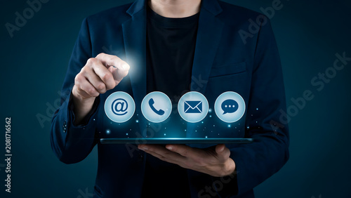 A business professional using a digital tablet with communication icons