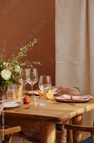 Table Set With Glasses and Flowers for a Meal in a Warm Room
