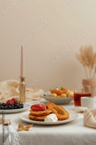 Breakfast Setup With Pastries, Fruits, and Tea on a Table in a Cozy Room