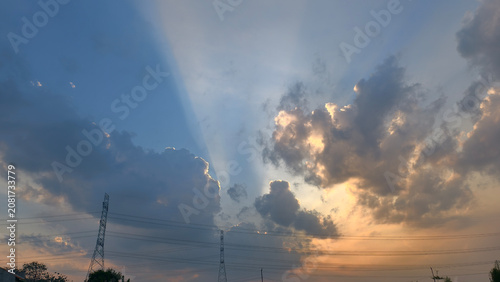 Schilderij op canvas Dramatic Sky with Sun Rays Breaking Through Dark Clouds at Sunset