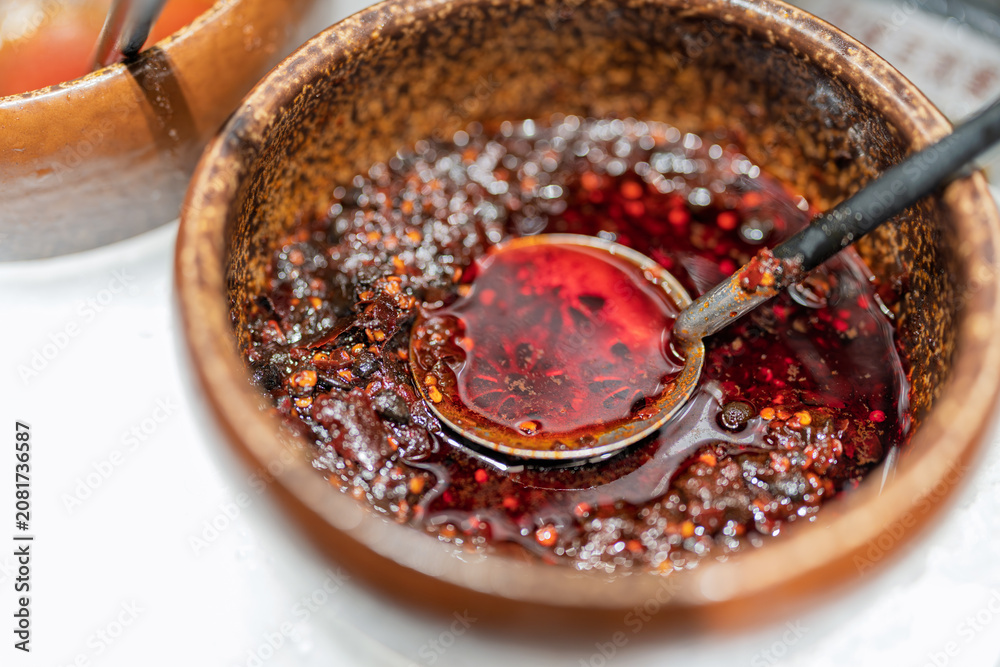 Fototapeta premium traditional chinese ceramic bowl filled with spicy red chili oil seasoning