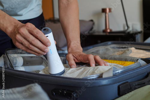 Canvas Print packing a suitcase with vacuum storage bags