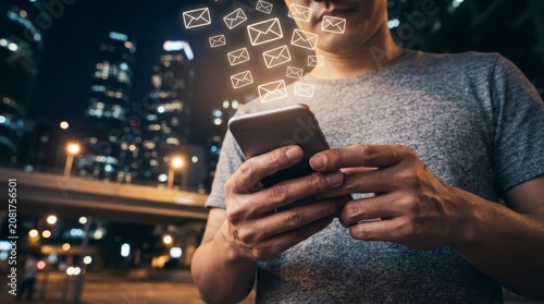 Man using smartphone with email notification icons