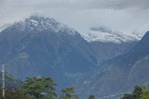 Schneebedeckte Alpengipfel im Meraner Land unter wolkenverhangenem Himmel in Südtirol