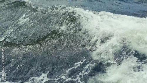 A serene and powerful view of a deep blue ocean surface, capturing the dynamic motion of waves from left to right