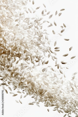 White rice grains falling against clear background, vertical