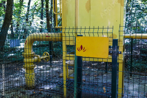 Close-up of yellow gas pipelines and control equipment inside a protected gas distribution facility. Industrial engineering infrastructure designed for safe natural gas transportation and regulatior