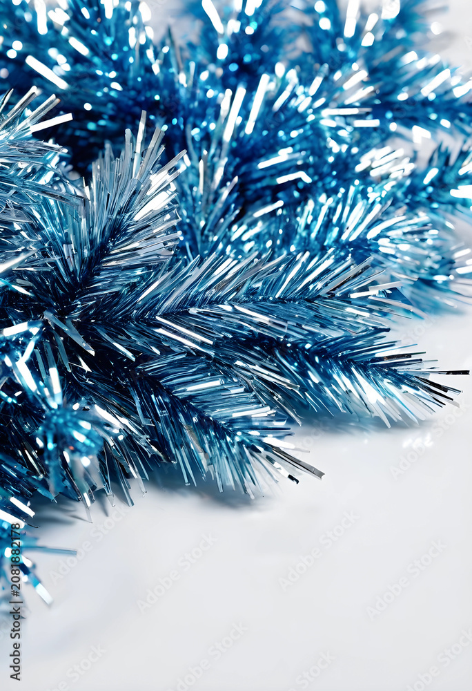 Fototapeta premium Blue metallic Christmas tinsel close-up on white background