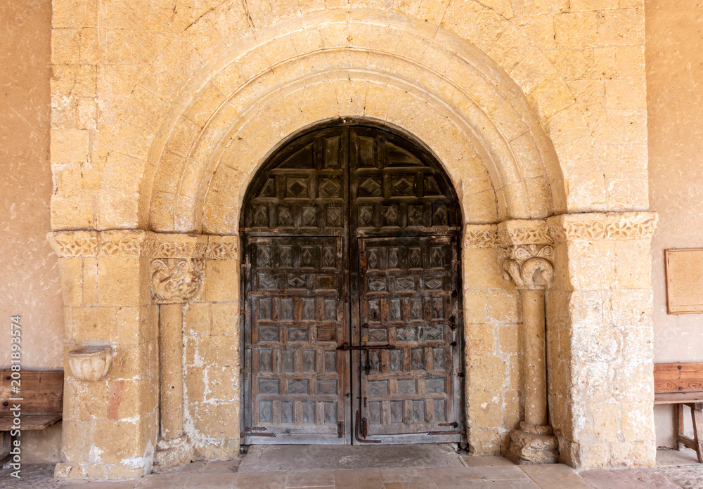 Fototapeta premium Romanesque Portal with Carved Archivolts and Decorated Wooden Door from the 12th to 13th Century Church of San Miguel in Sotosalbos, Segovia, Castile and Leon, Spain