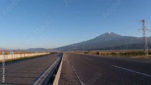 Truck drives along the highway past Mount Greater Ararat, view from the Turkish side