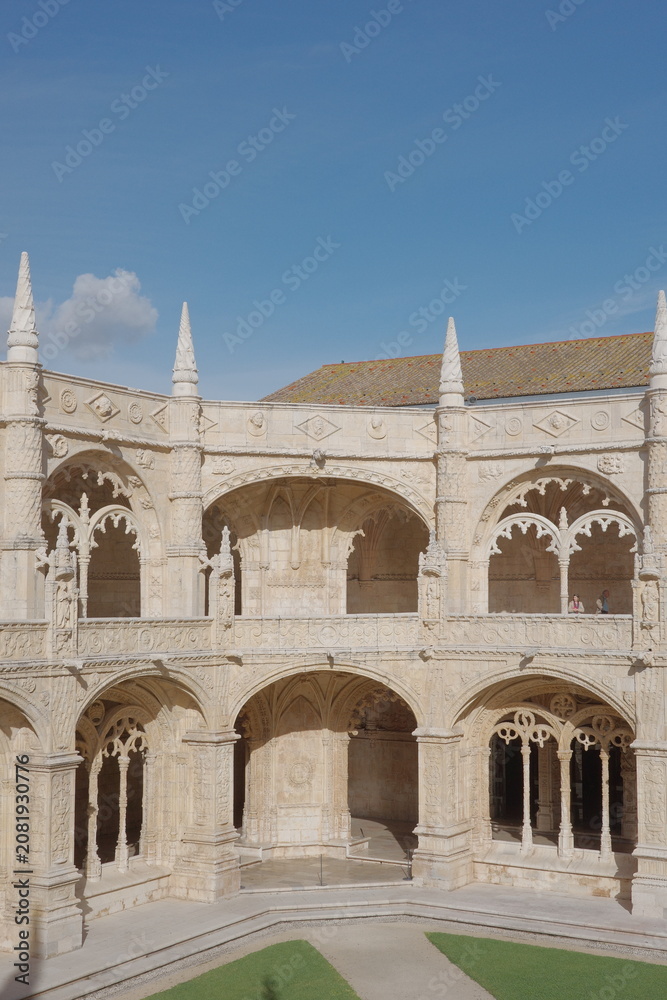 Obraz premium Jerónimos Monastery Cloister Arcade with Spires Against a Clear Blue Sky