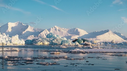Icebergs floating against majestic snowy mountains in arctic Svalbard