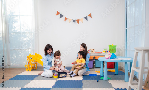 Children play with toys in a room with colorful furniture and a bright atmosphere during a sunny day