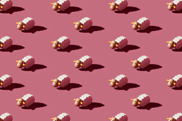 Pattern of small white sheep figurines against red background