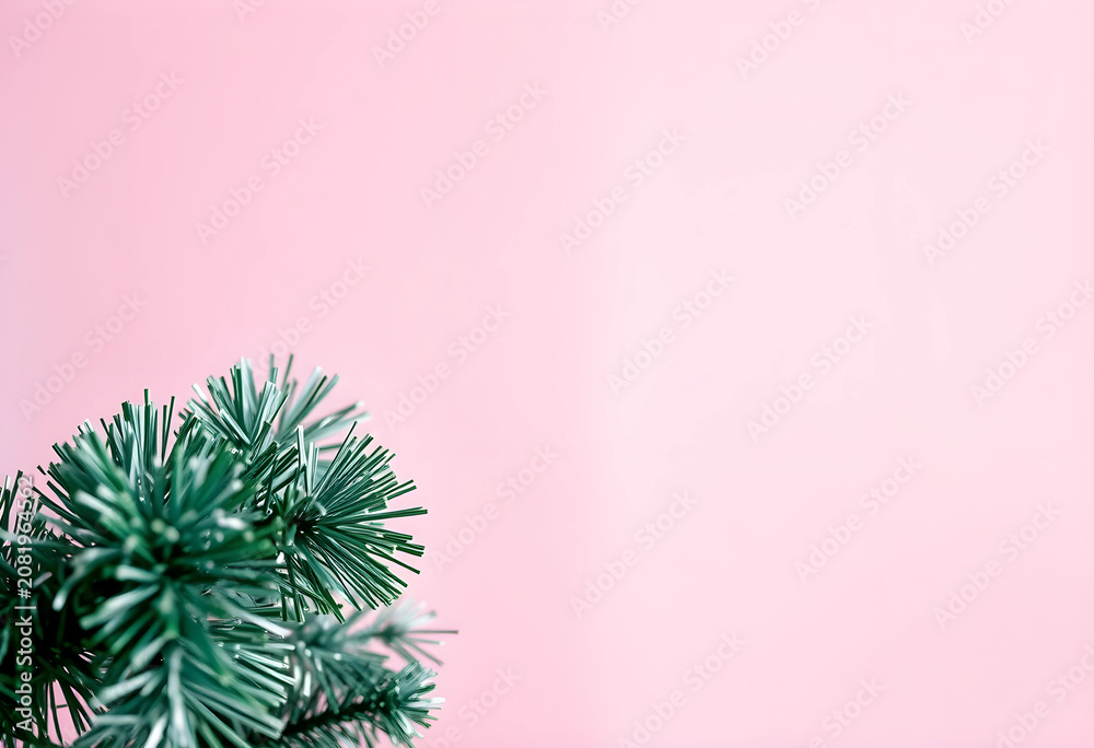 Fototapeta premium Close-up of green Christmas tinsel on pink background