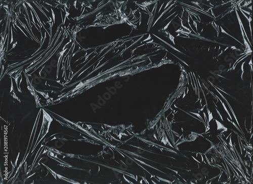 Принти на полотні Crumpled overlay texture of torn plastic on a black background