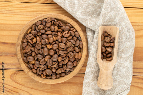 Roasted coffee beans with a wooden saucer. Top view. Macro.