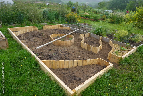 Permaculture garden beds with wooden borders ready for planting