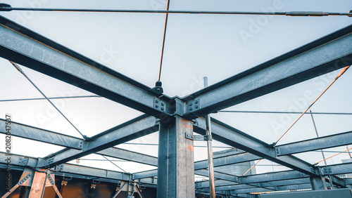 Fotografía Steel structural beams forming geometric frame against overcast sky