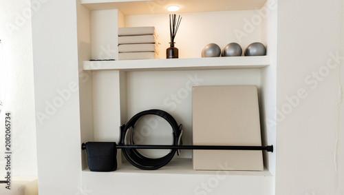 White interior niche displaying modern pilates and wellness items