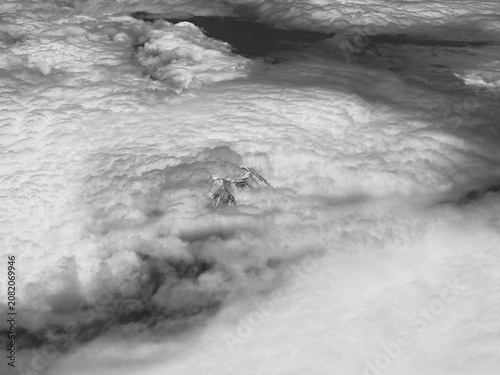 Aerial view of Mount Fuji peak emerging through a vast sea of clouds, with layered cloud forms and open sky above, creating a dramatic high-altitude landscape in Japan