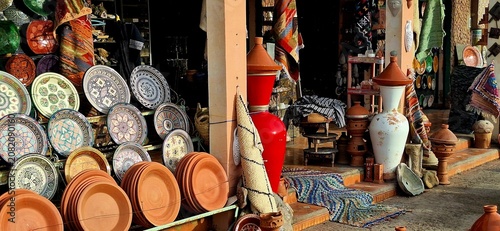 Photos Traditional Moroccan shop featuring handcrafted painted ceramics, pottery, and tagine cookware displayed outdoors