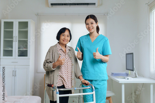 Senior woman with walker and caregiver showing thumbs up