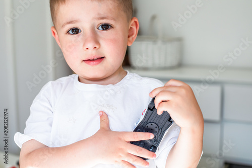 Foto Defenceless toddler holding toy tight protecting his last