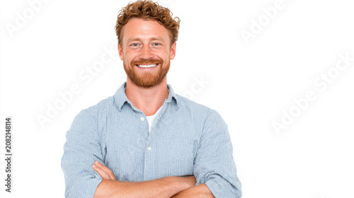 Businessman stands with his arms crossed while smiling against a white.