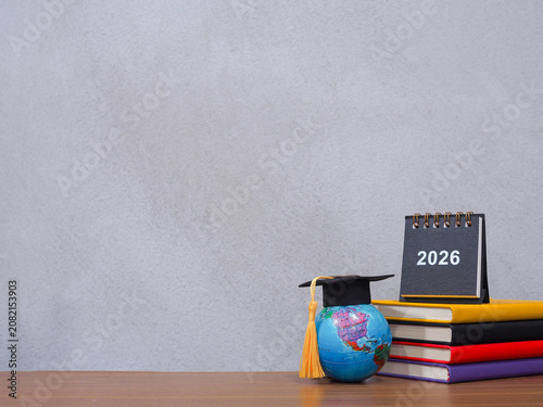 Cuadro en lienzo Student creative desktop, Earth globe with graduation hat and 2026 desk calendar on hardcover book
