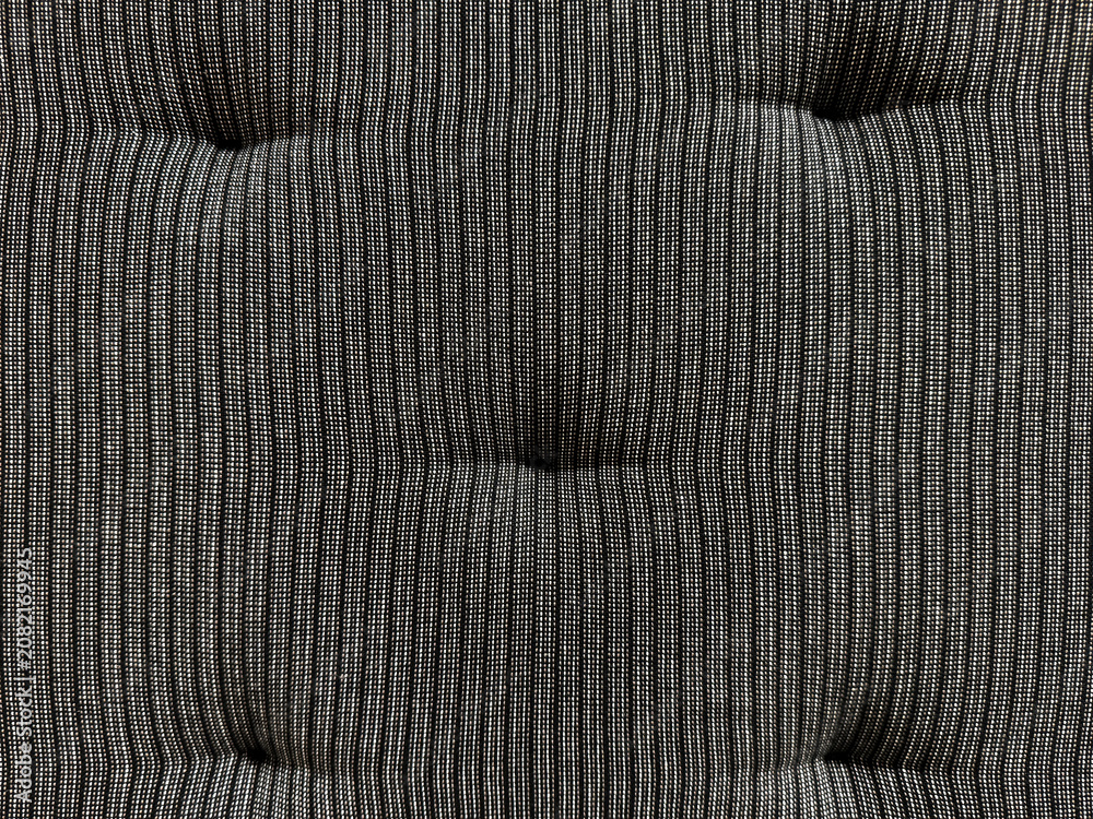 Naklejka premium Close up of black stripes fabric with recessed embossed button. Suitable for sofa cushion backing, padded, and upholstered panel. Seamless background texture.