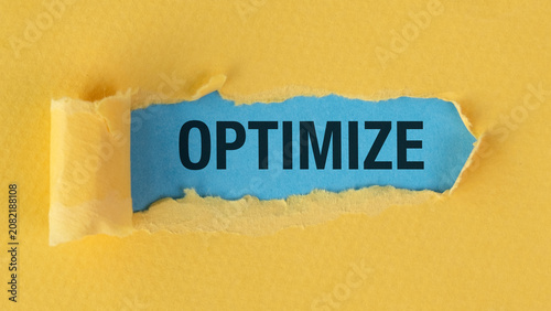 Bold word OPTIMIZE breaks through yellow paper. Sharp edges suggest change and improvement. Bright colors draw attention to the message.