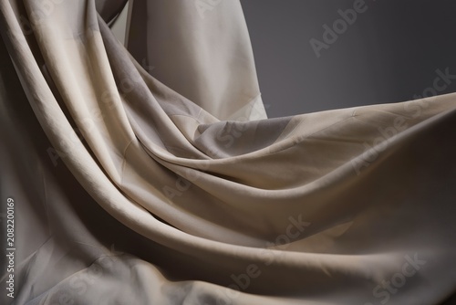 Fond abstrait en tissu beige drapé avec plis élégants et texture textile minimaliste
