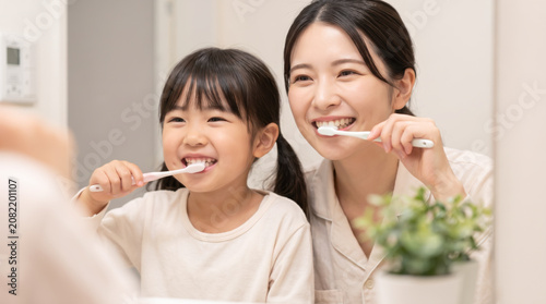 洗面所で仲良く食後の歯磨きをする親子