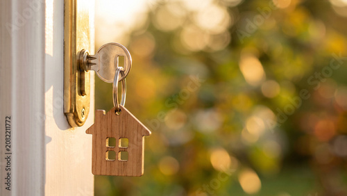 House Key with Wooden Home Keychain in Door Lock. Real Estate and Property Concept.