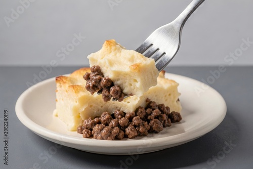 Cottage Pie with beef mince topped with mashed potatoes on white plate. Concept of comfort food, savory dish presentation ideal for culinary photography. 